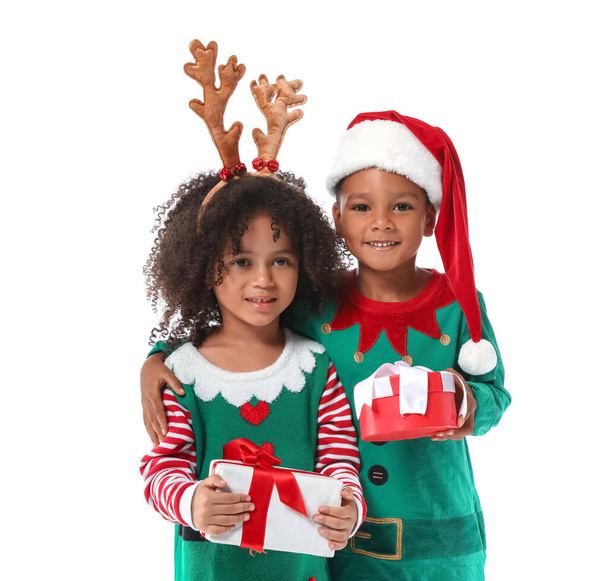 Pequeños niños afroamericanos vestidos de elfos con regalos sobre fondo blanco - Foto, Imagen