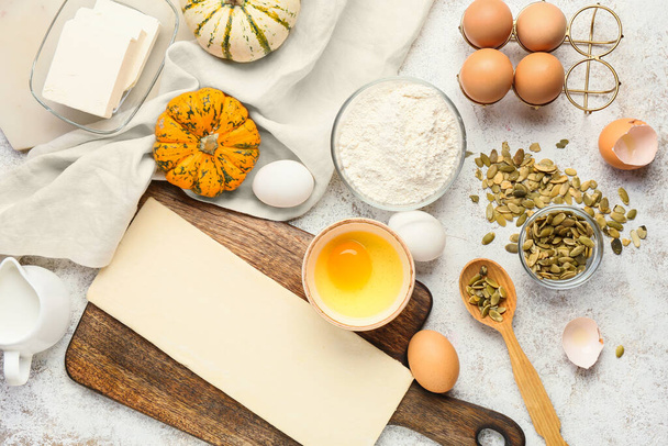 Raw dough and ingredients for preparing pumpkin strudel on light background - Photo, Image