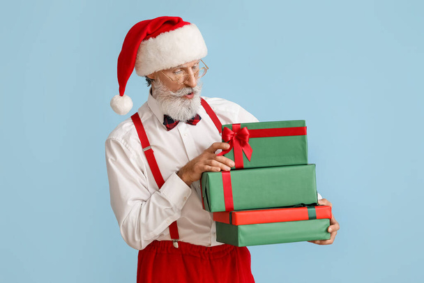 Kerstman met geschenken op kleur achtergrond - Foto, afbeelding