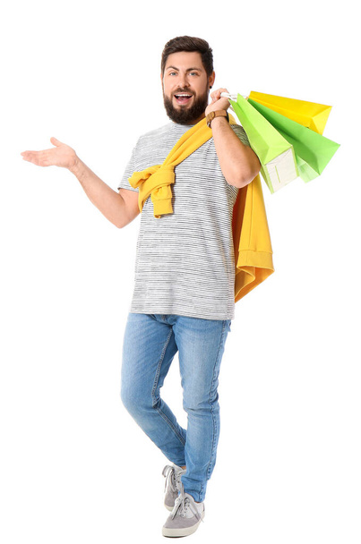 Schöner Mann mit Black-Friday-Einkaufstüten auf weißem Hintergrund - Foto, Bild