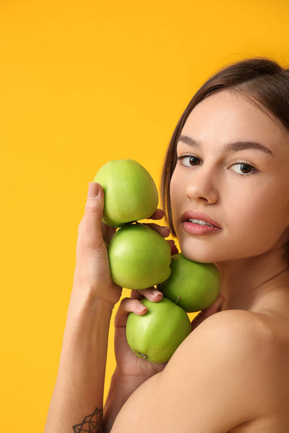 Nahá mladá žena s jablky na barevném pozadí. Veganský den - Fotografie, Obrázek