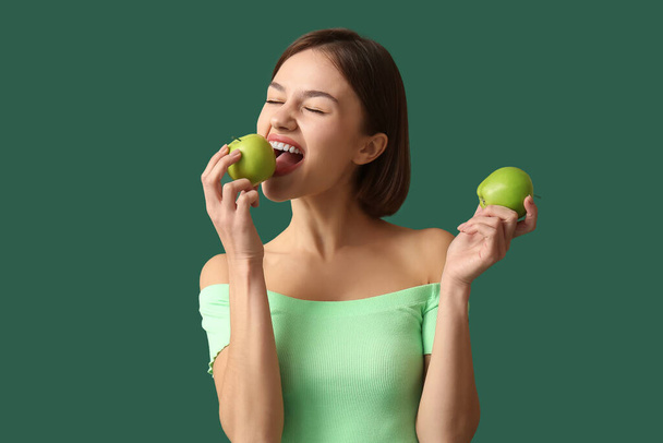 背景色にリンゴを持つ若い女性。ビーガンデー - 写真・画像
