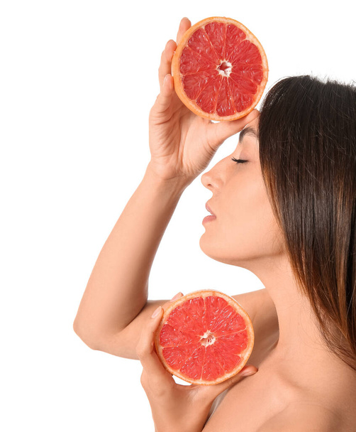 Naakte jonge vrouw met gesneden grapefruit op witte achtergrond. Veganistische dag - Foto, afbeelding