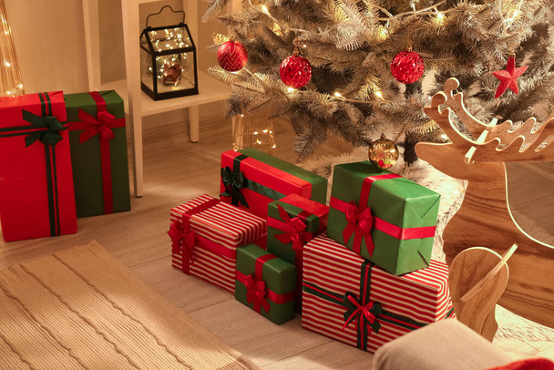 Δώρα κάτω από έλατο στο δωμάτιο την παραμονή των Χριστουγέννων - Φωτογραφία, εικόνα
