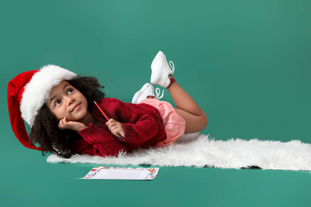 Cute African-American girl with letter to Santa on color background - Fotografie, Obrázek