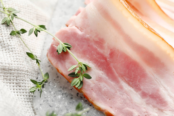Board with slices of smoked bacon on table, closeup - Photo, Image