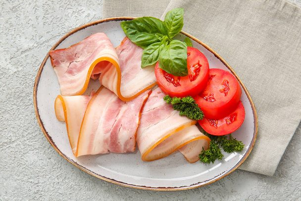 Talíř s plátky uzené slaniny na světlém pozadí - Fotografie, Obrázek