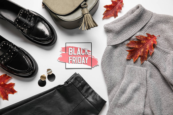 Stylish female clothes with accessories and text BLACK FRIDAY on white background - Fotoğraf, Görsel
