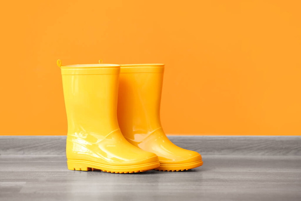 Par de botas de goma amarillas contra fondo de color - Foto, Imagen