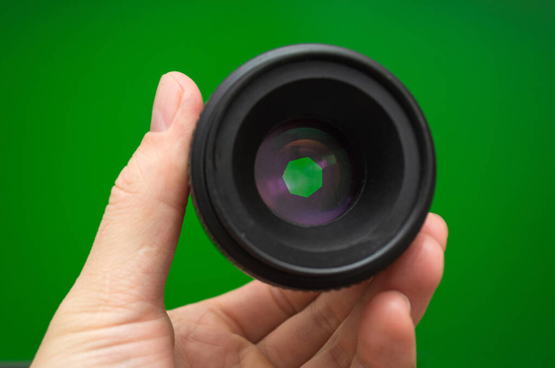 camera lens with open aperture on green background - Photo, Image