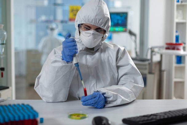 Επιστήμονας γυναίκα που αναλύει το αίμα χρησιμοποιώντας ιατρική micropipete - Φωτογραφία, εικόνα
