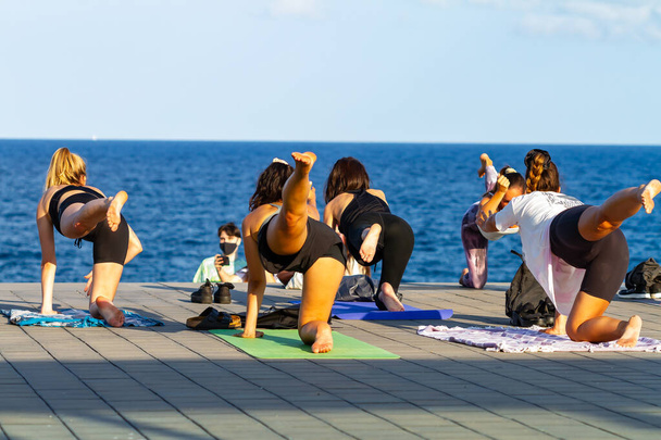 BARCELONA, SPAIN - Aug 02, 2021: A guided yoga class by the sea in Barcelona, Spain - Zdjęcie, obraz