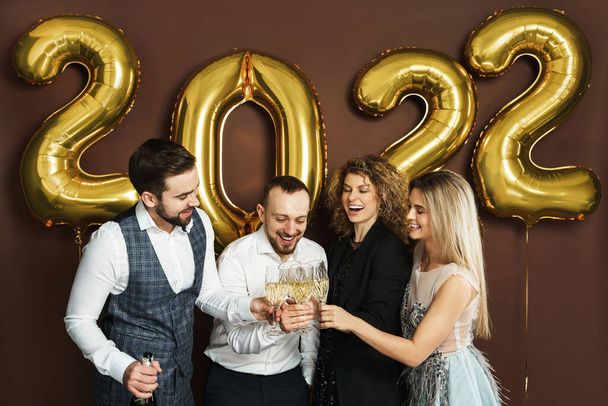 Gruppo di belle persone ben vestite che festeggiano il 2022 Capodanno e bevono spumante - Foto, immagini