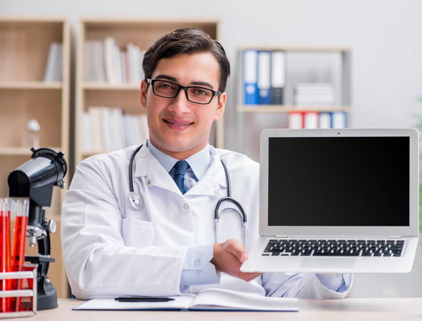 Junge erwachsene Ärztin mit Laptop - Foto, Bild