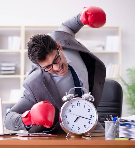 Θυμωμένος επιχειρηματίας με γάντια πυγμαχίας στην έννοια διαχείρισης του χρόνου - Φωτογραφία, εικόνα