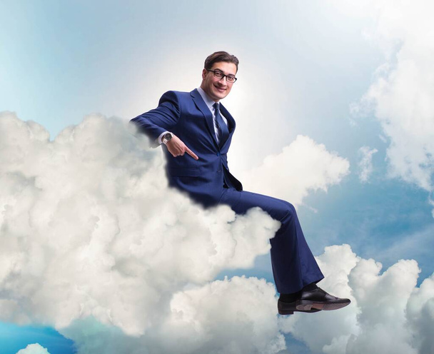 Uomo d'affari seduto sul cloud nel concetto di motivazione - Foto, immagini