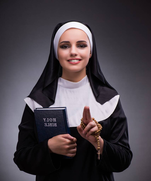 Religieuze nun in religie concept tegen de donkere achtergrond - Foto, afbeelding