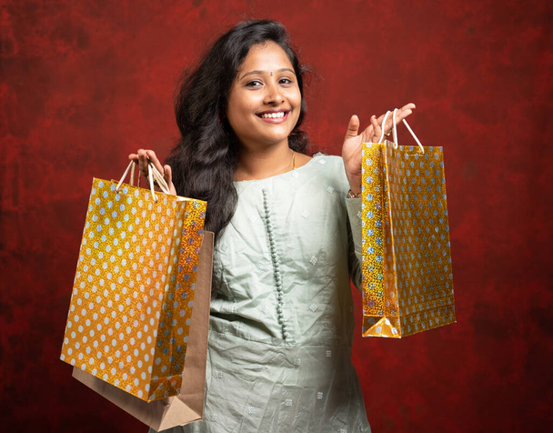 Alışveriş poşetleriyle gülümseyen Hintli kadın kameraya bakıyor - alışveriş ve bayram festivali alışverişini gösteren konsept ve - Fotoğraf, Görsel