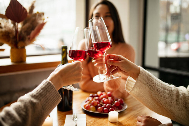 Großaufnahme von Weingläsern, die klirren. Nette Freunde treffen sich an warmen, sonnigen Tagen im Café - Foto, Bild
