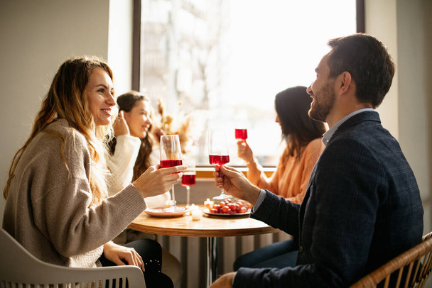 Baráti társaság, akik beszélgetnek a találkozón, bort isznak, desszertet esznek. - Fotó, kép