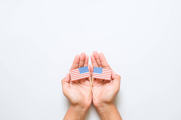 Hand holding and touching national mini American Flag. World veteran day concept - Foto, imagen