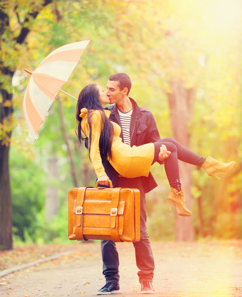 Paar mit Koffer küsst sich in Gasse im Park - Foto, Bild
