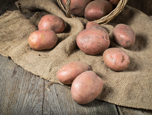 Raw potatoes on wooden background - Foto, afbeelding