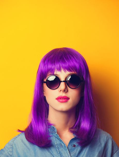 Beautiful girl with violet hair in sunglasses on yellow backgrou - Photo, Image