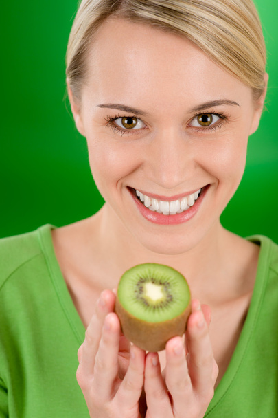 Healthy lifestyle - happy woman holding kiwi - Foto, imagen