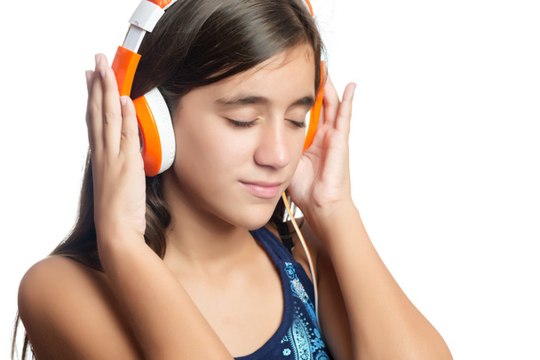 Beautiful hispanic teenage girl enjoying music on bright orange headphones - Foto, immagini