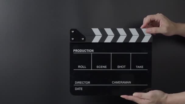 Στιγμιότυπο από ταινία. Ο άνθρωπος χέρι κρατώντας σχιστόλιθο ταινία και παλαμάκια στο στούντιο πριν από τη λήψη ή την εγγραφή. Πίνακας ή σχιστόλιθος ταινίας για εγγραφή βίντεο. παραγωγή ταινιών. κινηματογραφική βιομηχανία. - Πλάνα, βίντεο