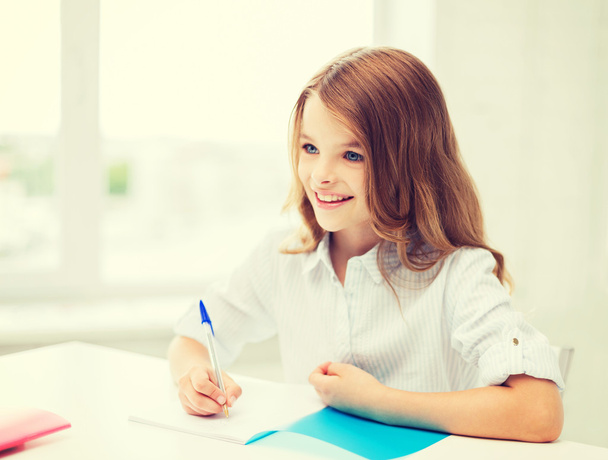 student girl writing in notebook at school - Valokuva, kuva