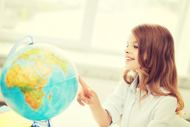 smiling student girl with globe at school - 写真・画像