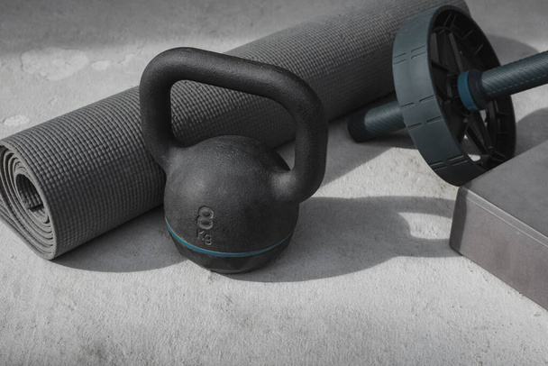 Kettlebell and yoga mat on the floor at home. gym equipment. - Фото, изображение
