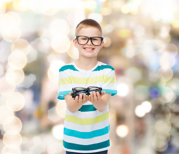 smiling boy in eyeglasses holding spectacles - Foto, Bild