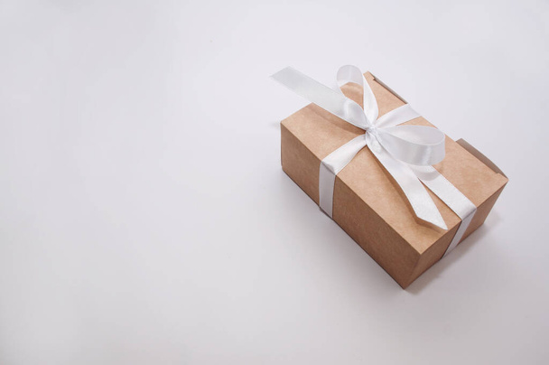pudełko na prezenty związane z białą satynową wstążką na białym tle z miejscem do podpisu - Zdjęcie, obraz