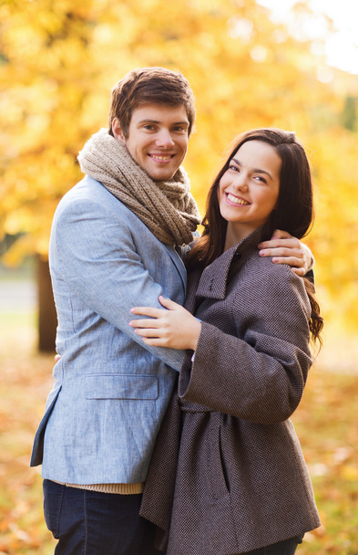 улыбающаяся пара обнимается в осеннем парке - Фото, изображение