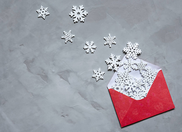 red envelope with snowflakes on a grey background. - Foto, imagen