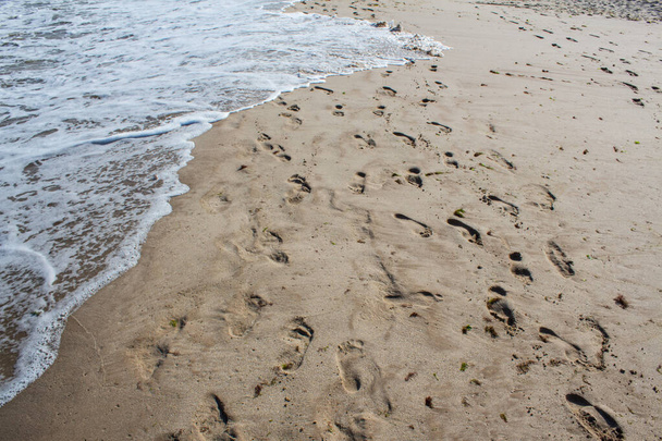 Het water van de Zwarte Zee wassen voetafdrukken op het Albena strand in Bulgarije. - Foto, afbeelding