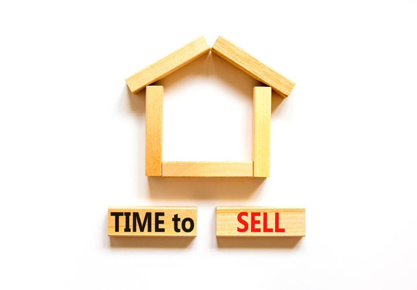 Time to sell house symbol. Concept words 'Time to sell' on wooden blocks near miniature house. Beautiful white background, copy space. Business and time to sell house concept. - Fotografie, Obrázek