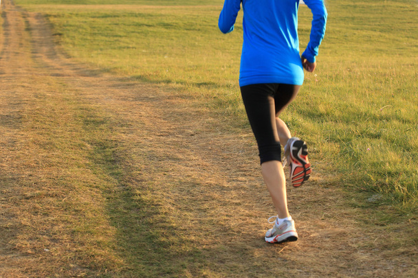 Runner athlete running on grass seaside. - Photo, Image