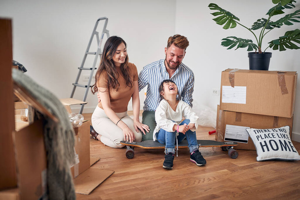 Happy playful mixed family moving in new apartment and playing together  - Foto, Imagem