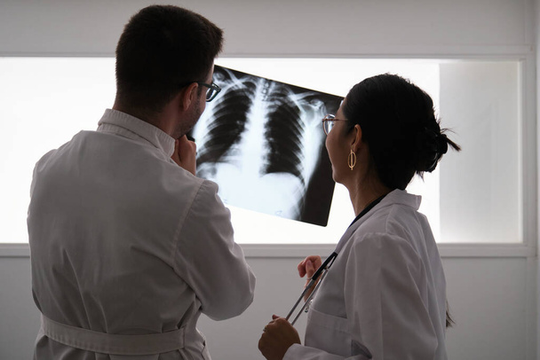 Professioneel medisch team dat een patiënt radiografie onderzoekt. - Foto, afbeelding