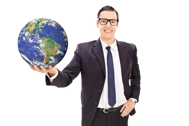Young businessman holding the earth - 写真・画像