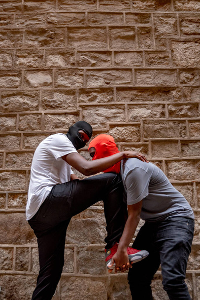 Dos jóvenes afro en pasamontañas en callejón - Foto, Imagen