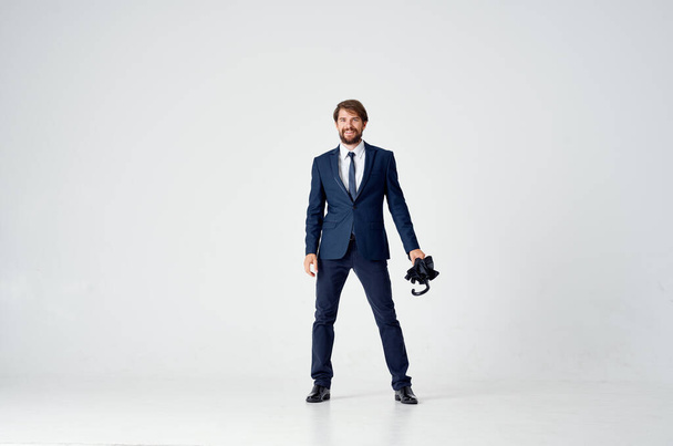 uomo d'affari in giacca e cravatta con un ombrello elegante protezione antipioggia stile - Foto, immagini
