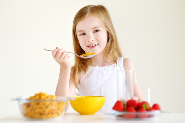 Girl eating cereal with milk - Фото, изображение