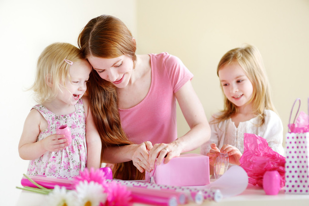 Mother and daughters with gift - Photo, image