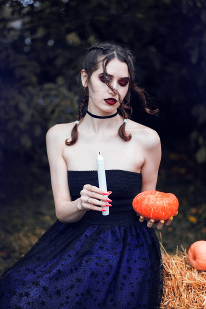 Девушка по образу ведьмы. Идея фотосессии на Хэллоуин. Ужасно красивая. Голубое платье, свечи, тыквы, дым. Атрибуты Хэллоуина. Фотосессия - Фото, изображение