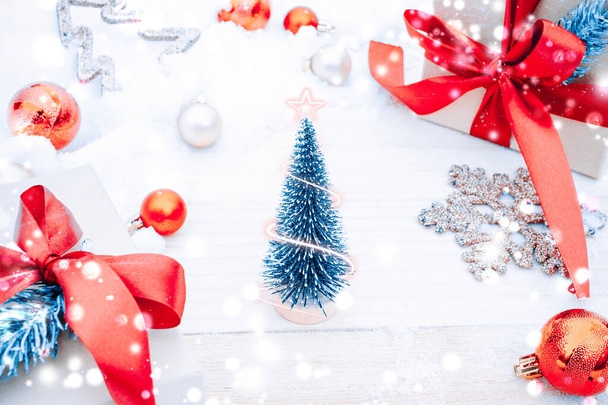 雪の木。冬の木製の装飾の背景。古い素朴な壁、白い冷凍雪のフレーク、黄金のボールとギフトボックス付きのクリスマスボード。メリークリスマスの休日カードパターン - 写真・画像